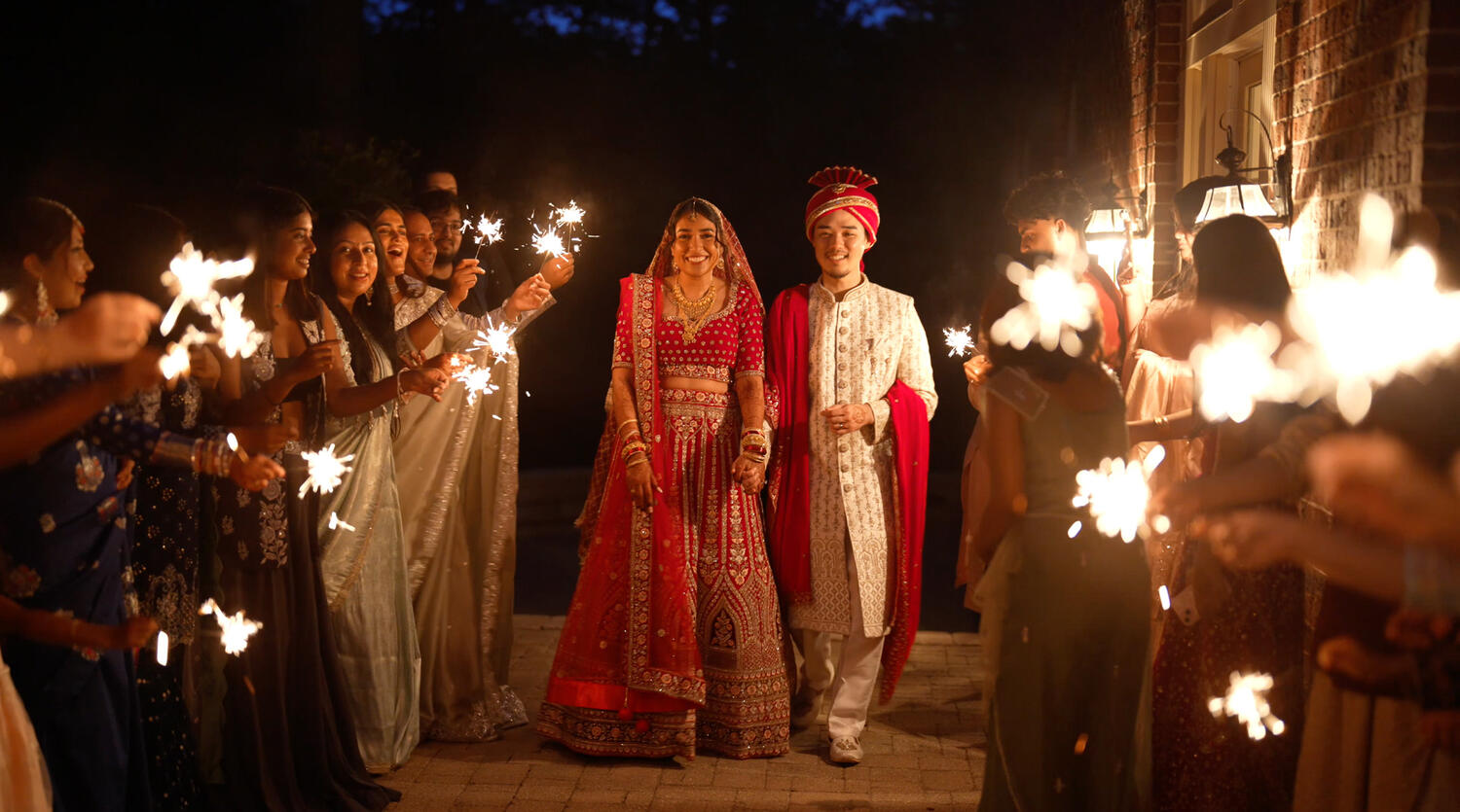Bride and groom exiting through a sparkler send-off at night